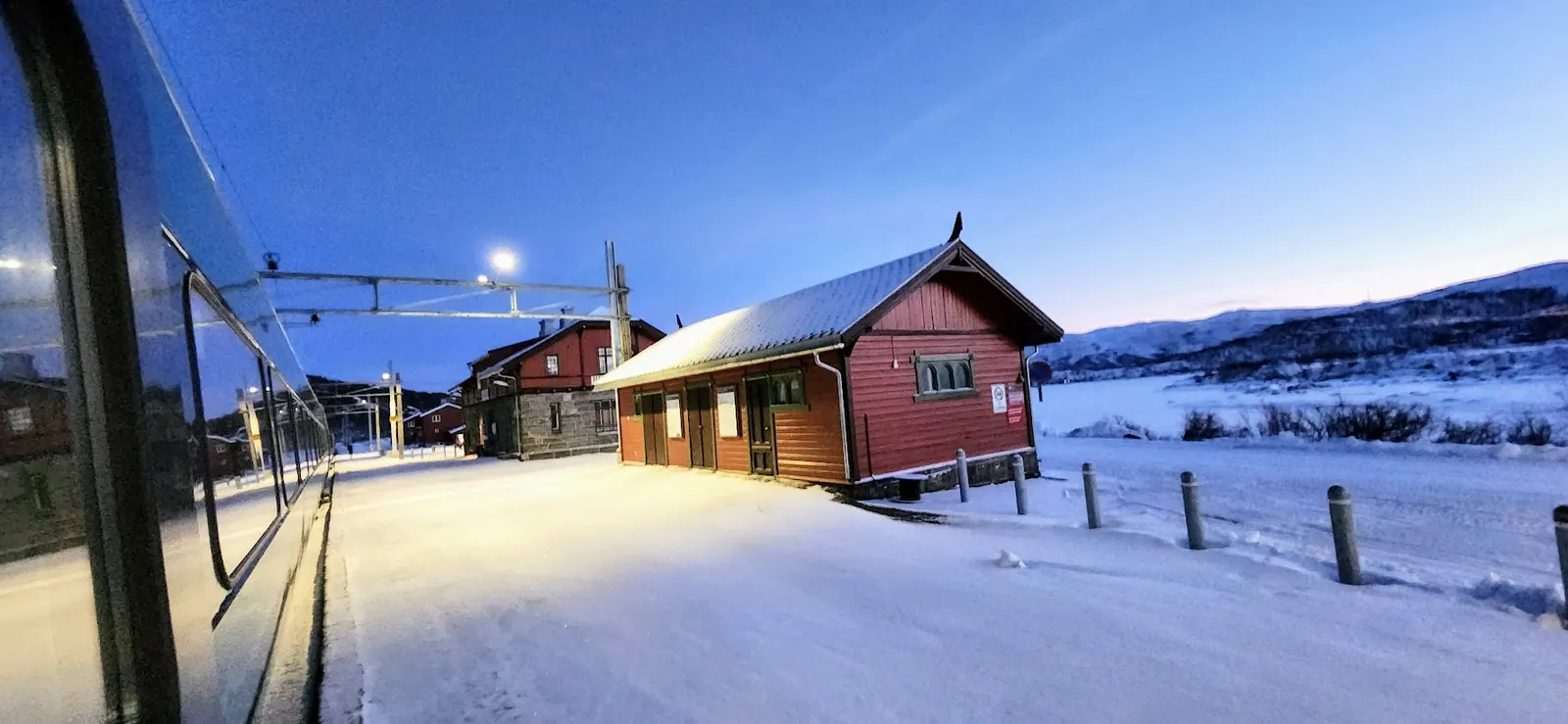 Snow-covered railway platform at blue hour